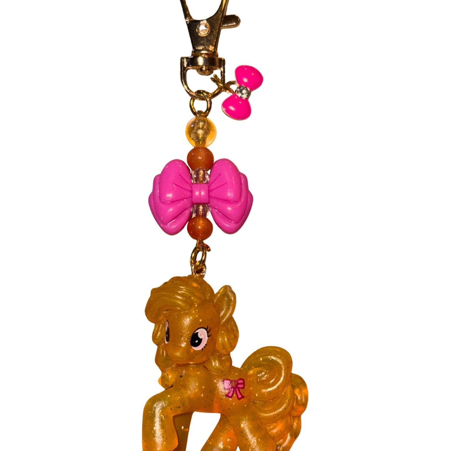 Keychain with a small pony figure and pink bow on a white background